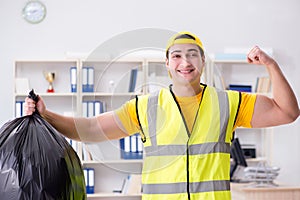 The man cleaning the office and holding garbage bag