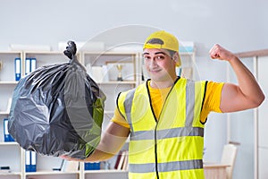 The man cleaning the office and holding garbage bag