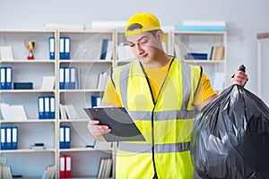 The man cleaning the office and holding garbage bag