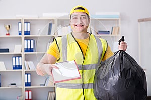 The man cleaning the office and holding garbage bag