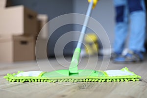 Man cleaning office, mopping floor from laminate