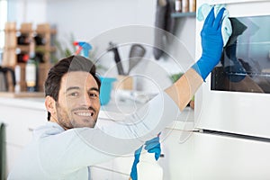 man cleaning oven in kitchen