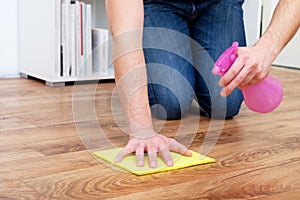 A man cleaning a parquet with one sponge