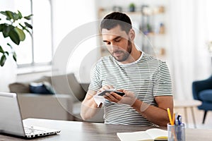 Man cleaning phone with wet wipe at home office