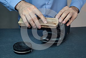 Man cleaning shoes with brush.