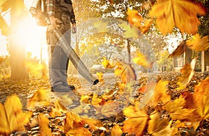 Man cleaning the sidewalk with a leaf blower photo