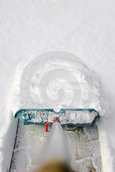 Man cleaning snow with shovel in winter day.