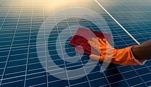 Man cleaning solar panel on roof. Solar panel or photovoltaic module maintenance. Sustainable resource and renewable energy for go