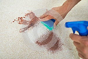 Man Cleaning Stain On Carpet With Sponge photo