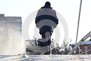 Man cleaning the street from snow manual tractor special