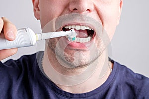 Man cleaning teeth with electric tooth brush