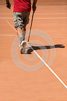 Man cleaning tennis terrain photo