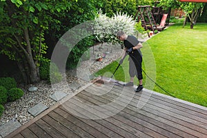 man cleaning terrace with a power washer