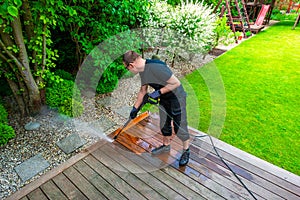 man cleaning terrace with a power washer