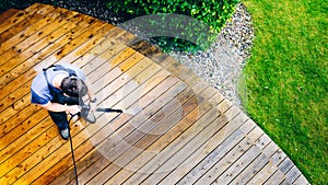 man cleaning terrace with a power washer - high water pressure c