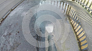 Man cleaning terrace with a power washer - high water pressure cleaner on wooden terrace railing