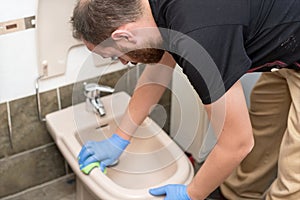 Man cleaning toilet bidet