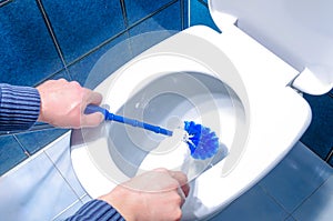Man Cleaning Toilet Using Brush and Liquid Cleaner