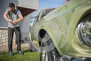 Man cleaning vintage car windows