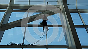 Man is cleaning windows on a highrise building.