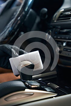 Man cleans a car part with a melamine sponge