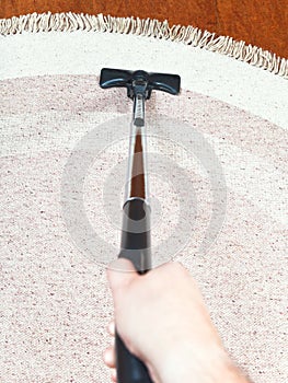 Man cleans a carpet with hoover