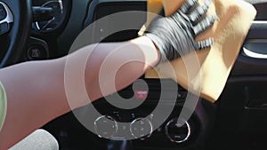 A man cleans the interior of a car with a microfiber cloth. Cleaning the dashboard of the car