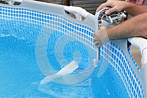 Man cleans skimmer for the frame pool. Contaminated pool cleaning concept