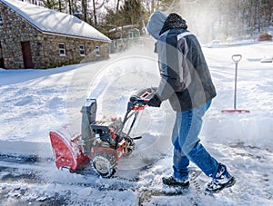 Man clearing his driveway of snow  with a snowblower