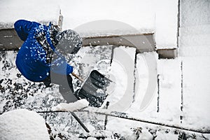 Man is clearing the snow on staircases, snow pusher and shovelling photo