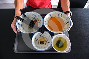 Man clearing tray of used crockery after dining. Diners at coffee shops, food courts are expected to clear their tables, dirty