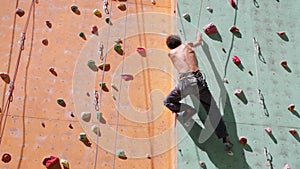 Man climber is climbing on the outdoors climbing gym