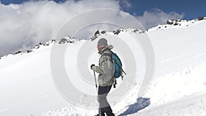 A man climber, descends the snow-covered slope down to the base camp. Mount Elbrus, the Caucasus Mountains.