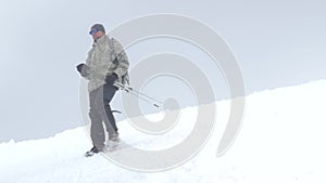 A man climber, descends the snow-covered slope down to the base camp. Mount Elbrus, the Caucasus Mountains.