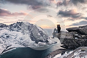 Man climber sitting on ridge rock with sightseeing snow mountain on ryten mount