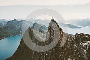 Man climber standing on cliff mountain edge above fjord in Norway