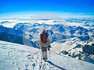 Man climber on top of a beautiful snow-capped mountain. The concept of extreme recreation and adventure.