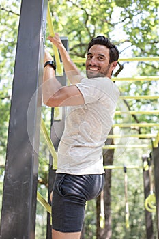man climbing bars in park