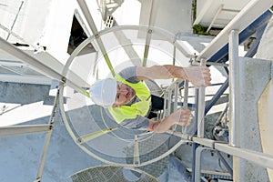 man climbing fixed ladder telecommunication tower