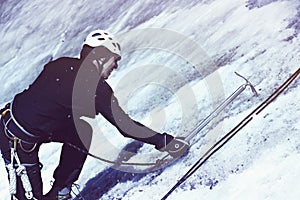 Man is climbing with ice ax on the glacier.