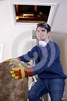 Man Climbing Into Loft To Insulate House Roof