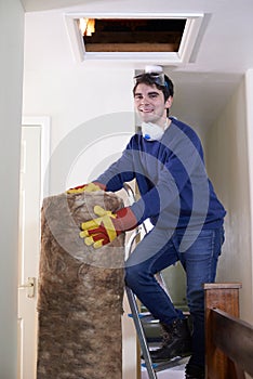 Man Climbing Into Loft To Insulate House Roof photo