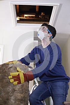 Man Climbing Into Loft To Insulate House Roof photo