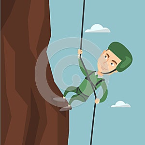 Man climbing a mountain with a rope.