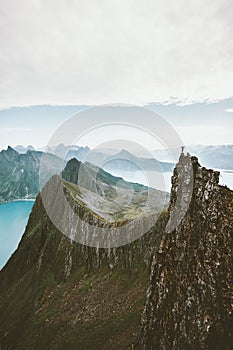 Man climbing in Norway traveler standing on cliff