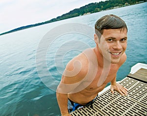 Man climbing onto pier