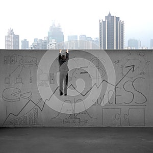Man climbing over wall with business doodles