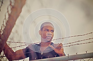 Man climbing over wire fence