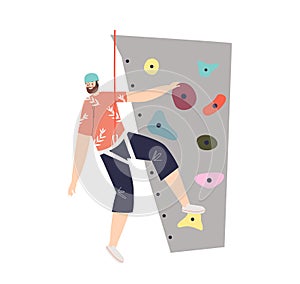 Man climbing rock or wall in gym or adventure park. Male climber hanging wearing protective ropes