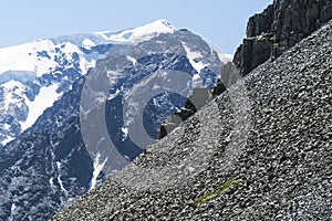 man climbing steep mountain. Good image for adventure, struggle and success story photo. Amateur mountaineering against the blue